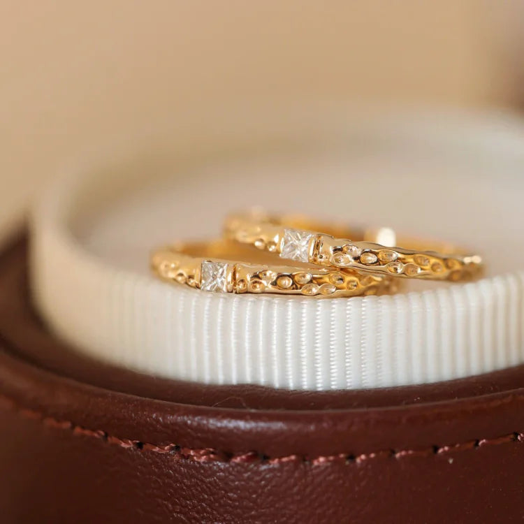 Goldene Eheringe mit Diamanten auf braunem Lederetui, luxuriöser Schmuck, Hochzeit, Verlobung.