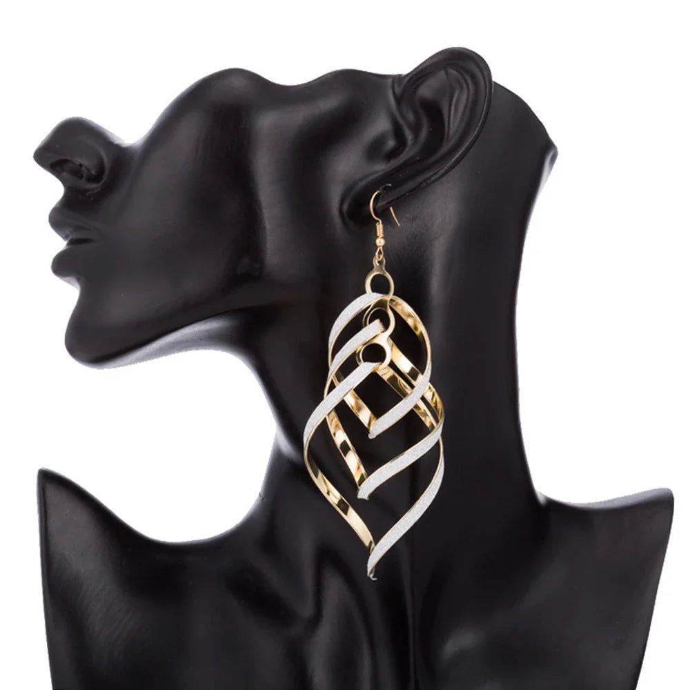 Goldene, spiralförmige Ohrringe an schwarzem Mannequin, Modeschmuck, elegant, modern.