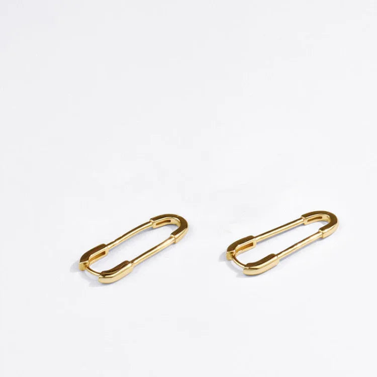 Zwei goldene Sicherheitsnadeln, minimalistisch, Schmuck, Accessoire, Mode, elegant, Metall.