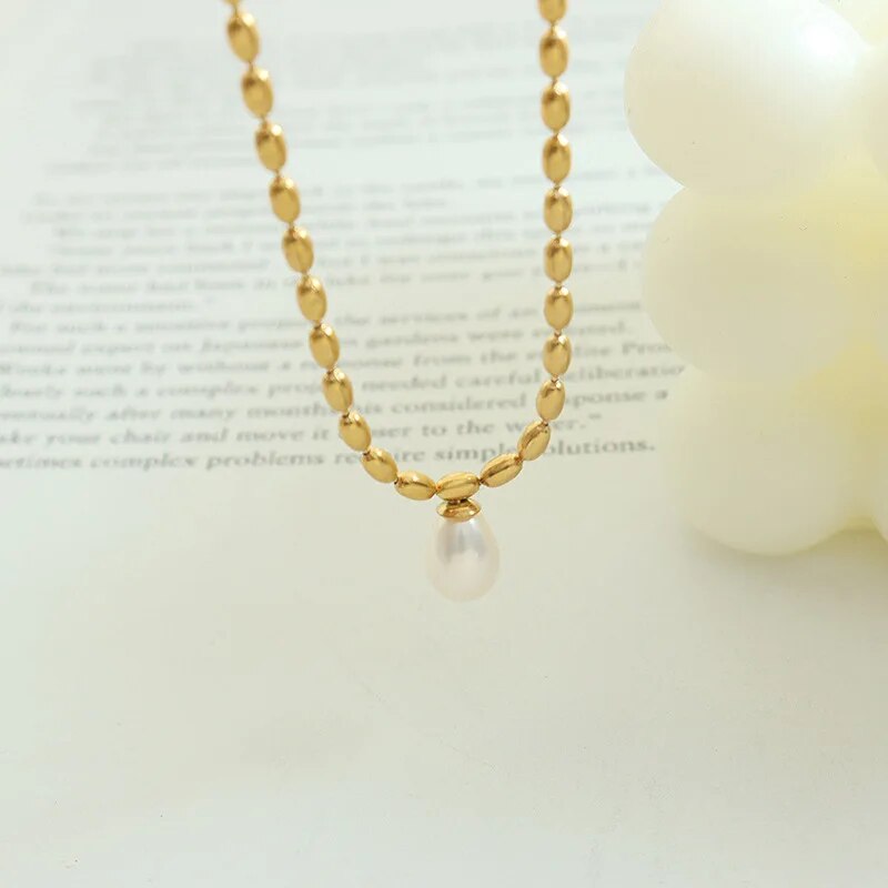 Goldene Halskette mit Perlenanhänger, eleganter Schmuck, Damenaccessoire, luxuriöses Design.