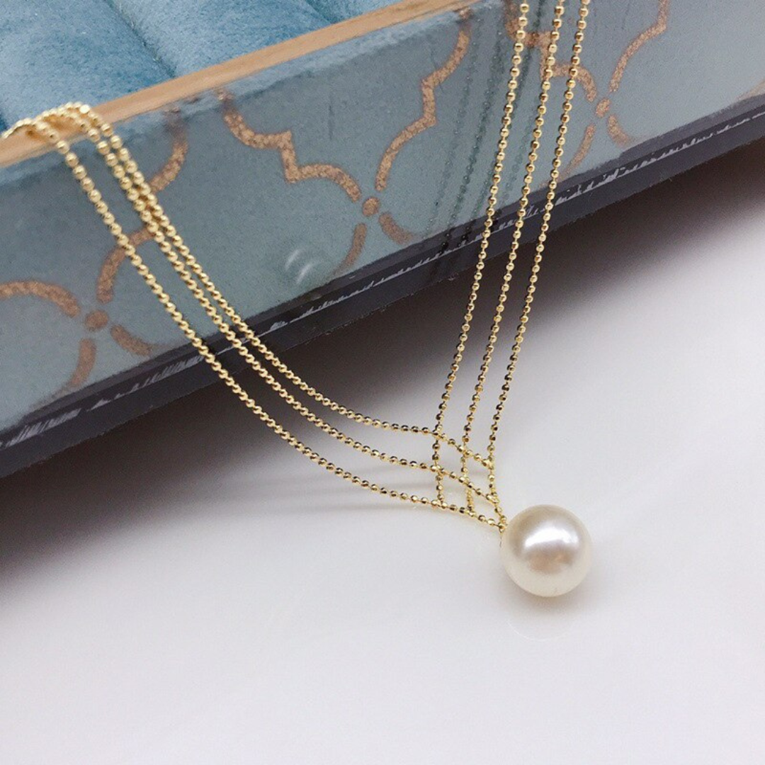 Goldene Halskette mit Perlenanhänger, elegantes Schmuckdesign, luxuriöses Accessoire.