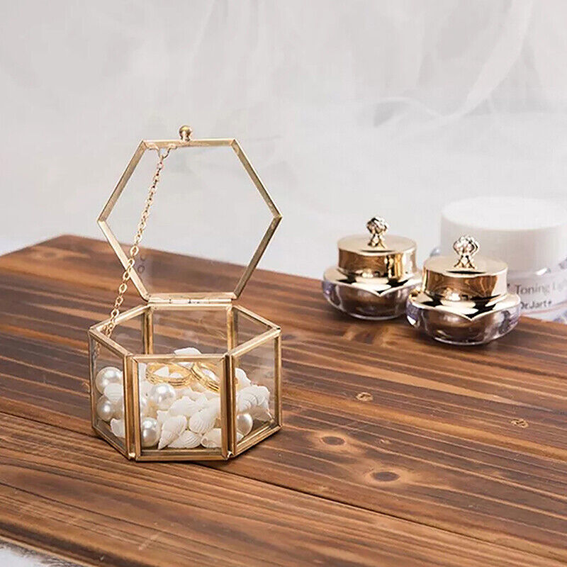 Goldene sechseckige Schmuckbox mit Perlen, Glas, dekorativ, auf Holztisch, luxuriöses Design.
