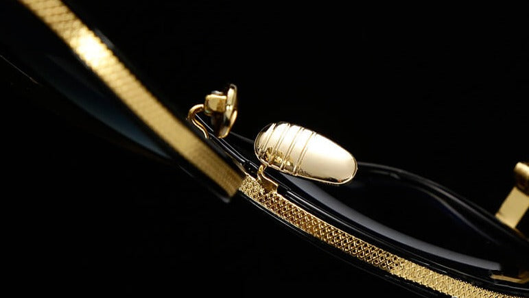 Goldene Designer-Brille, Nahaufnahme, luxuriöses Metallgestell, stilvolle Optik, schwarz-gold.