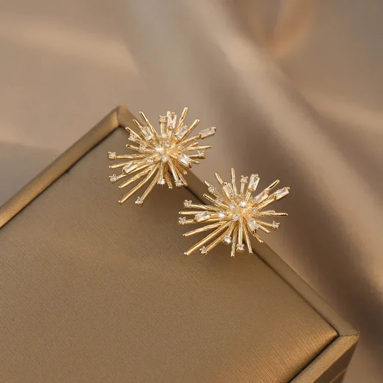 Goldene Ohrringe in Sternform auf beigem Hintergrund, eleganter Schmuck, modisches Accessoire.