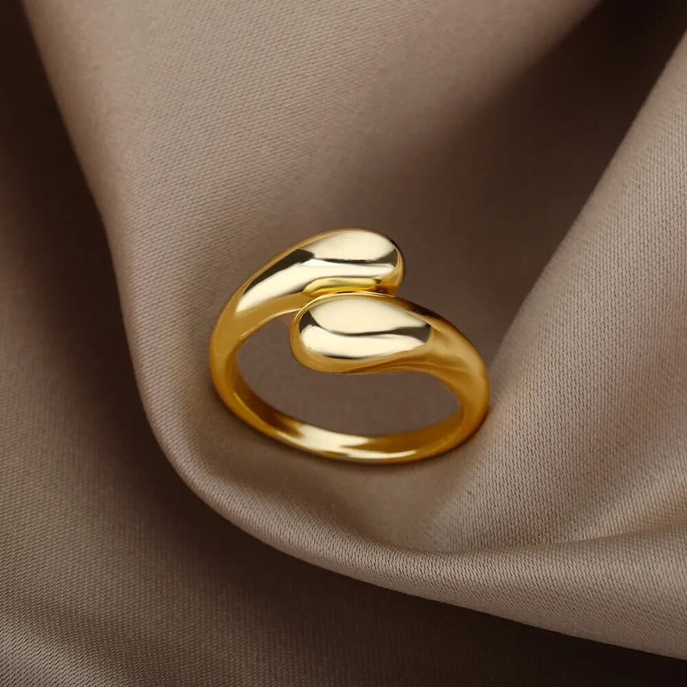 Goldener, minimalistischer Ring auf beigem Stoff, elegantes Schmuckdesign, glänzend, modern.