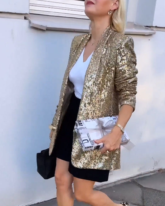 Frau in goldenem Paillettenblazer, weißem Top, schwarzem Rock, hält Zeitungstasche.