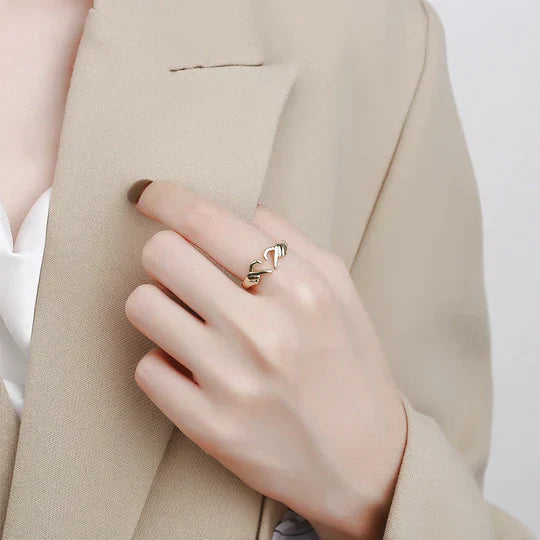 Goldener Damenring mit Herzdesign, getragen an der Hand, eleganter Schmuck, modisches Accessoire.
