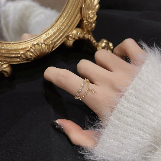 Goldener Ring mit Kristallen, Damenhand, Spiegel, eleganter Schmuck, Modeaccessoire, Nahaufnahme.