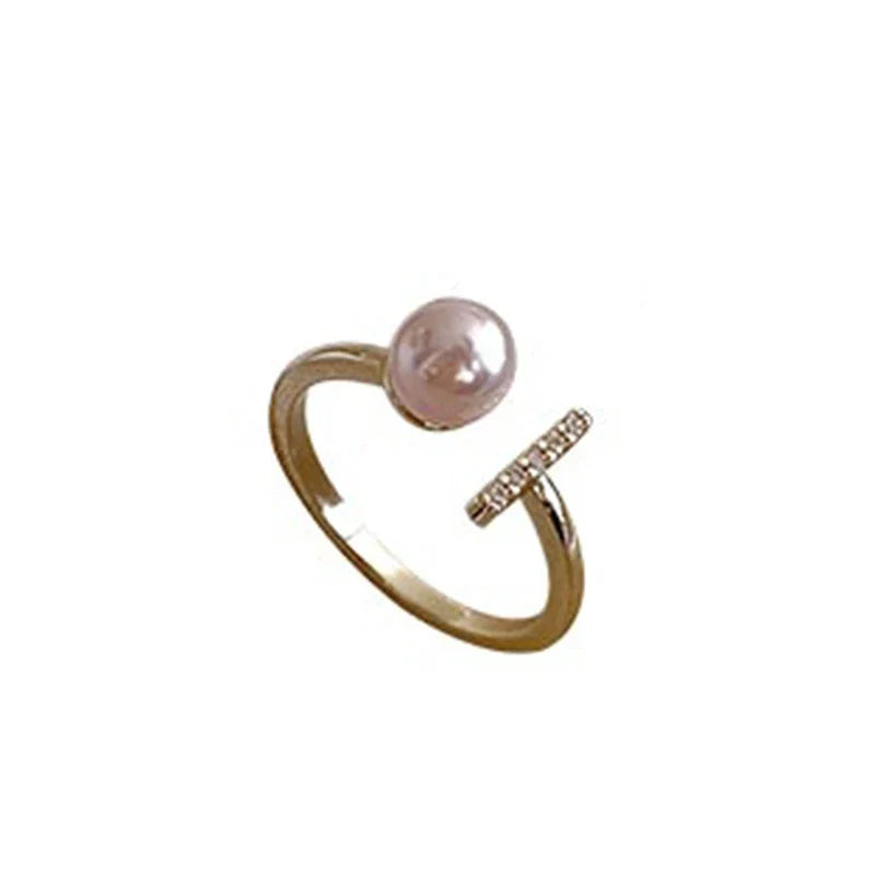 Goldener Ring mit rosa Perle und Diamantbesatz, eleganter Schmuck, modisches Accessoire.
