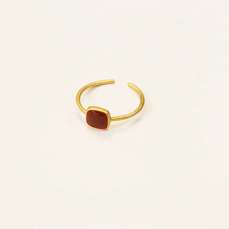 Goldener verstellbarer Ring mit rotem Stein, minimalistisches Schmuckdesign, modisch und elegant.