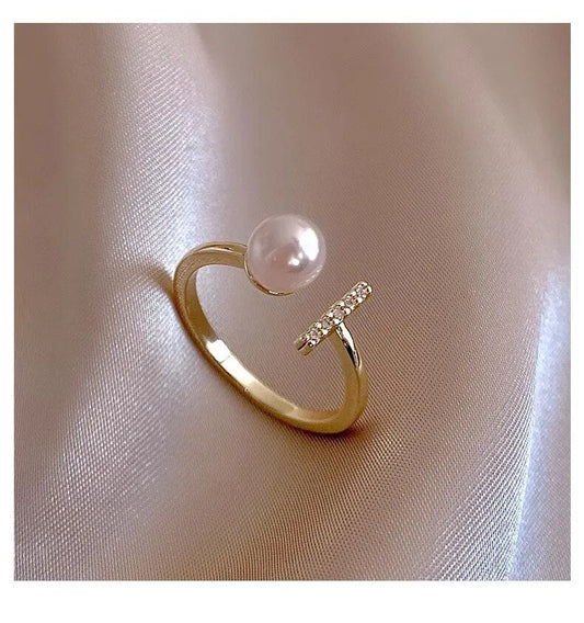 Goldener Ring mit Perle und Diamanten auf Seide, eleganter Schmuck, luxuriöses Design.