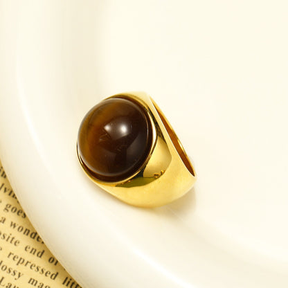 Goldener Ring mit braunem Edelstein, elegantes Schmuckdesign, luxuriöses Accessoire.