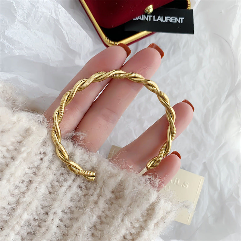 Goldener Edelstahl-Twist-Armreif für Damen, modisches Design, eleganter Schmuck.