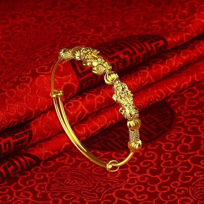 Goldenes Armband mit Drachenmotiv auf rotem Seidenstoff, chinesisches Design, Schmuck.
