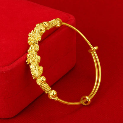 Goldenes Armband mit Drachenmotiv, verstellbar, auf rotem Hintergrund, Schmuckdesign.