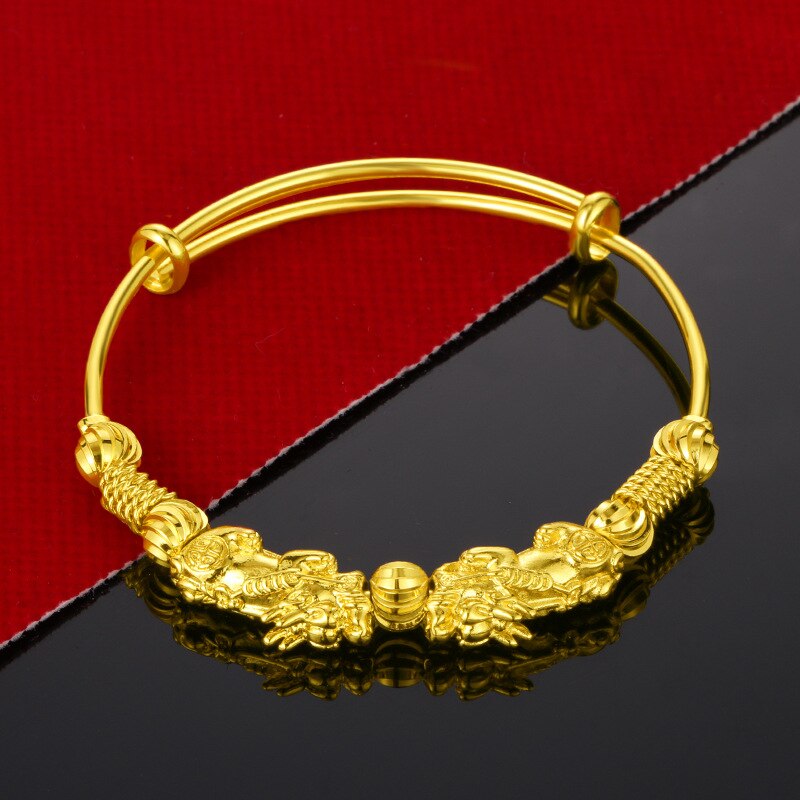 Goldenes Armband mit Drachenmotiv, verstellbar, auf rotem und schwarzem Hintergrund.
