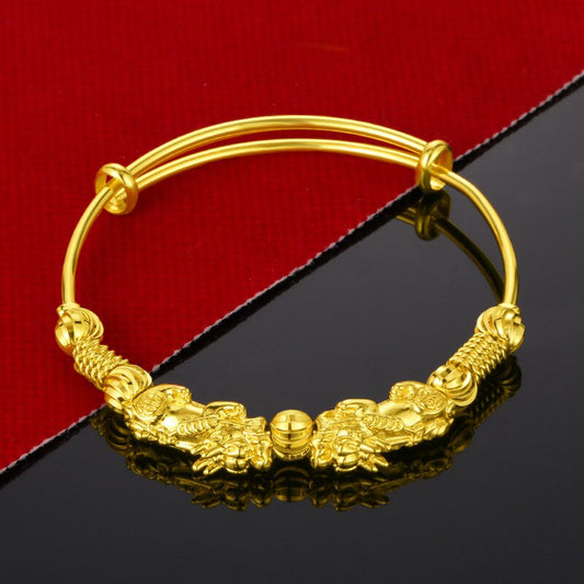 Goldenes Armband mit Drachenmotiv, verstellbar, auf rotem und schwarzem Hintergrund.