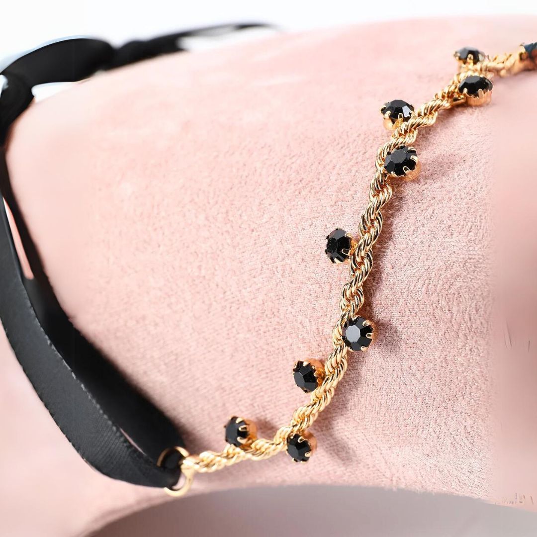 Goldenes Armband mit schwarzen Steinen, elegantes Schmuckdesign, Damenaccessoire.