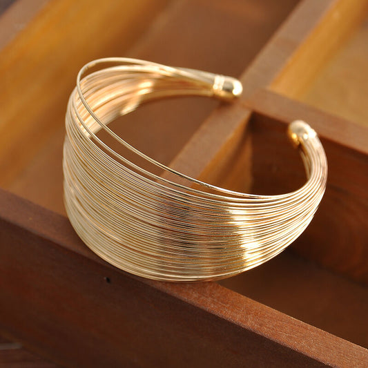 Goldenes Armreif aus Draht, elegantes Design, Modeschmuck, Damenaccessoire, Geschenkidee.
