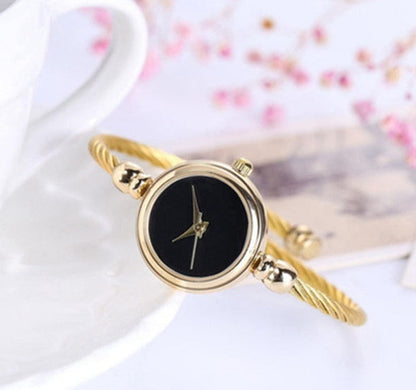 Goldenes Damenarmbanduhr mit schwarzem Zifferblatt, elegantes Design, modisches Accessoire.