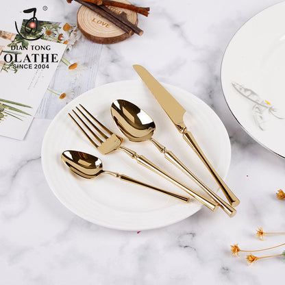 Goldenes Besteckset auf weißem Teller, Edelstahl, modernes Design, luxuriöses Essgeschirr.