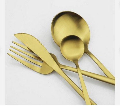 Goldenes Besteckset aus Edelstahl, bestehend aus Messer, Gabel, Löffel, auf weißem Hintergrund.