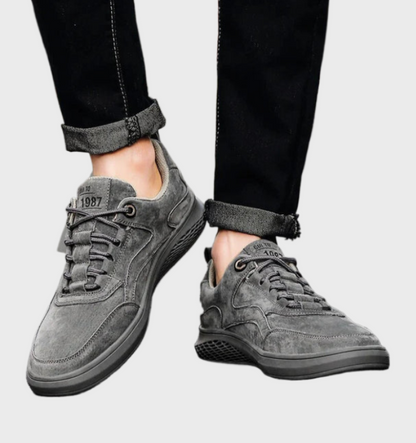 Graue Wildleder-Sneaker für Herren, lässig, bequem, modisch, mit schwarzer Jeans.