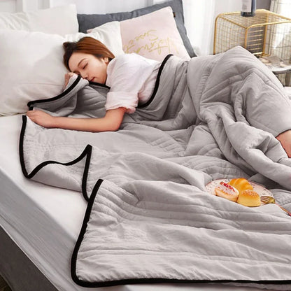 Frau schläft unter grauer Bettdecke, gemütliches Schlafzimmer, moderne Einrichtung, Entspannung.