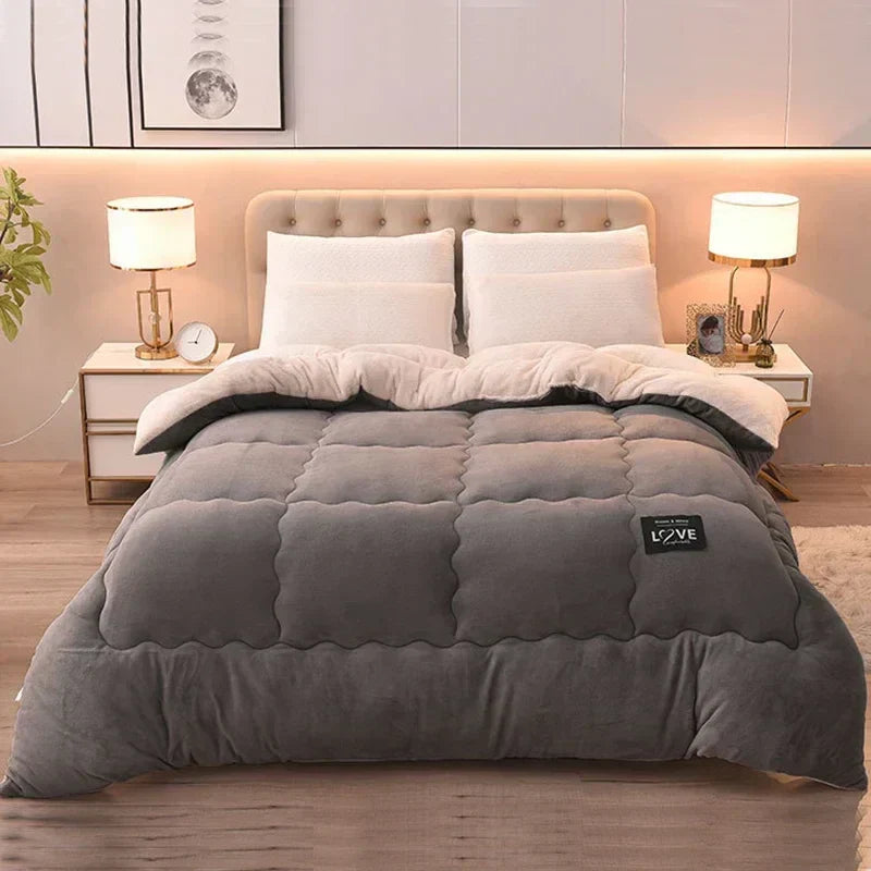 Graue Steppdecke auf Bett mit beigem Kopfteil, zwei Nachttische, moderne Schlafzimmerdekoration.