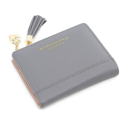 Graues Lederportemonnaie mit Quaste, goldener Schriftzug, stilvoll, kompakt, Damenaccessoire.