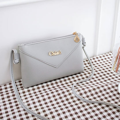 Graue Damenhandtasche aus Leder mit Schulterriemen, elegantes Design, goldene Details.
