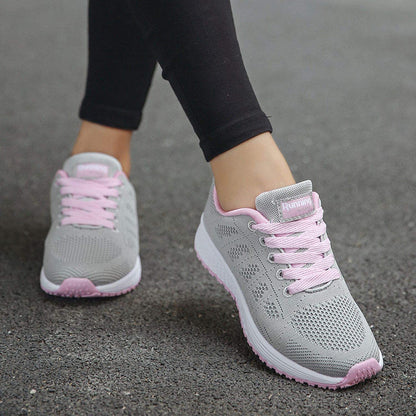 Graue Damen-Laufschuhe mit rosa Schnürsenkeln, atmungsaktiv, ideal für Sport und Freizeit.