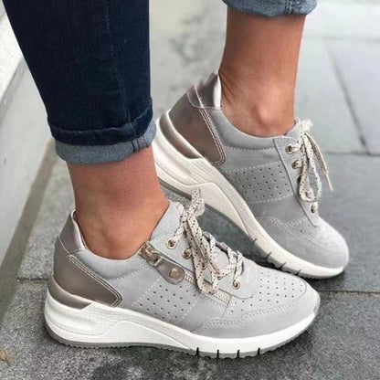 Graue Damen-Sneaker, Leder, perforiert, mit Schnürsenkeln, modisch, bequem, Straßenszene.
