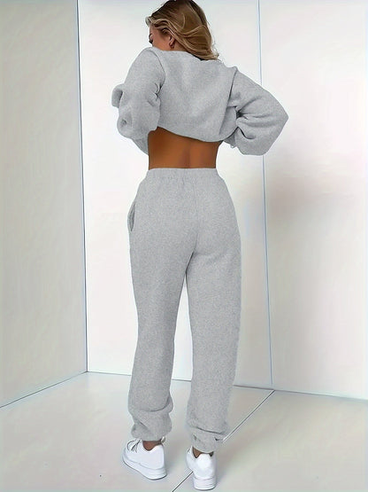 Frau in grauem Jogginganzug, Rückenansicht, Sportbekleidung, gemütlich, modisch, Indoor.
