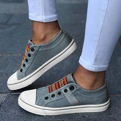 Graue Damen-Sneaker ohne Schnürsenkel, bunte Streifen, Freizeitschuhe, weißer Gummisohle.