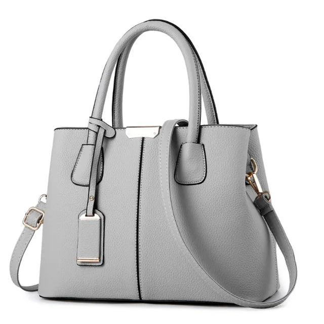 Graue Damenhandtasche aus Leder mit Schulterriemen, elegant und modern, für Alltag und Büro.