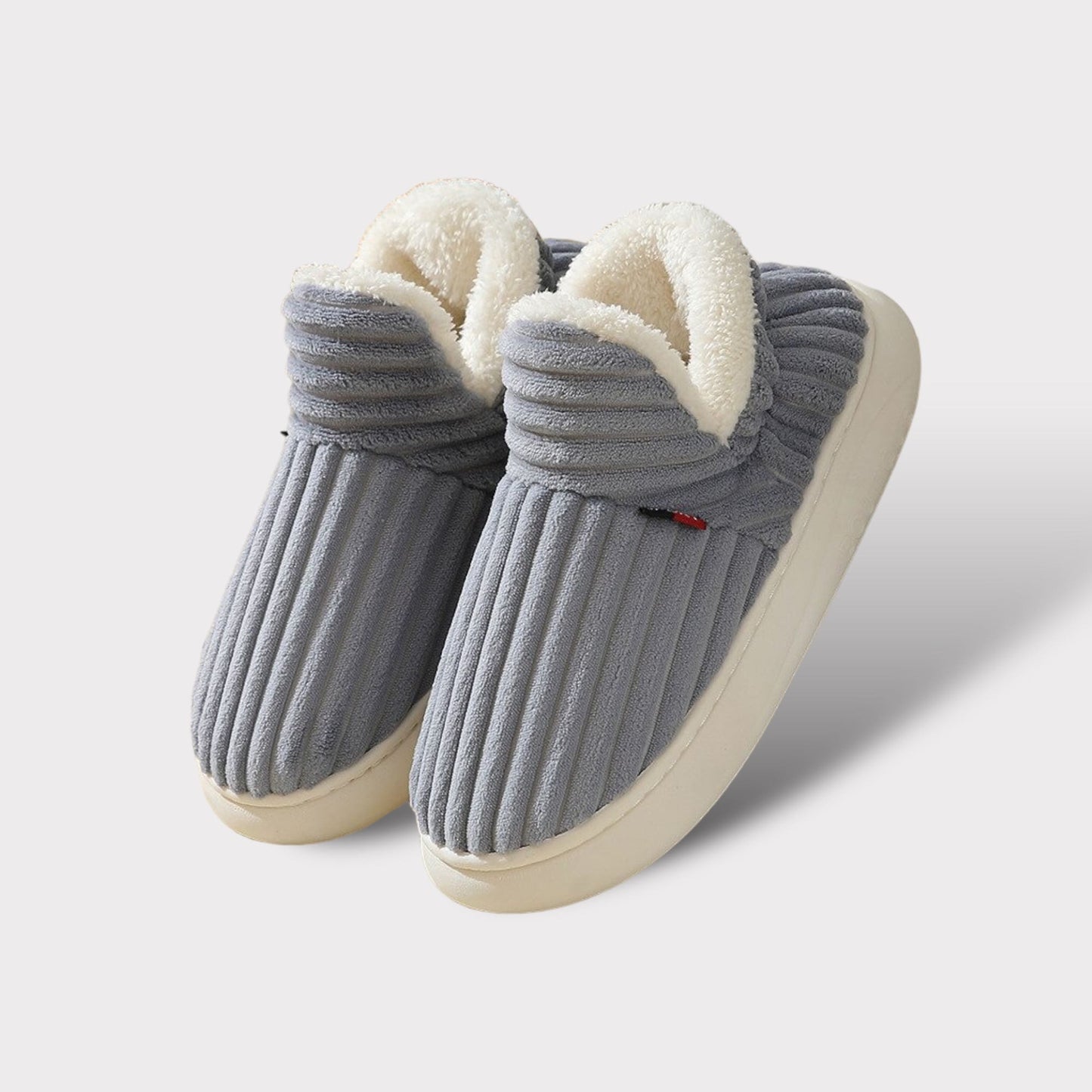 Graue Hausschuhe aus Fleece mit weißem Innenfutter, rutschfeste Sohle, gemütlich und warm.
