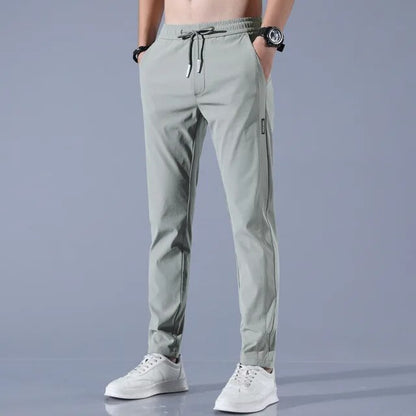 Herren Jogginghose, hellgrau, elastisch, mit Kordelzug, sportlich, bequem, modern.