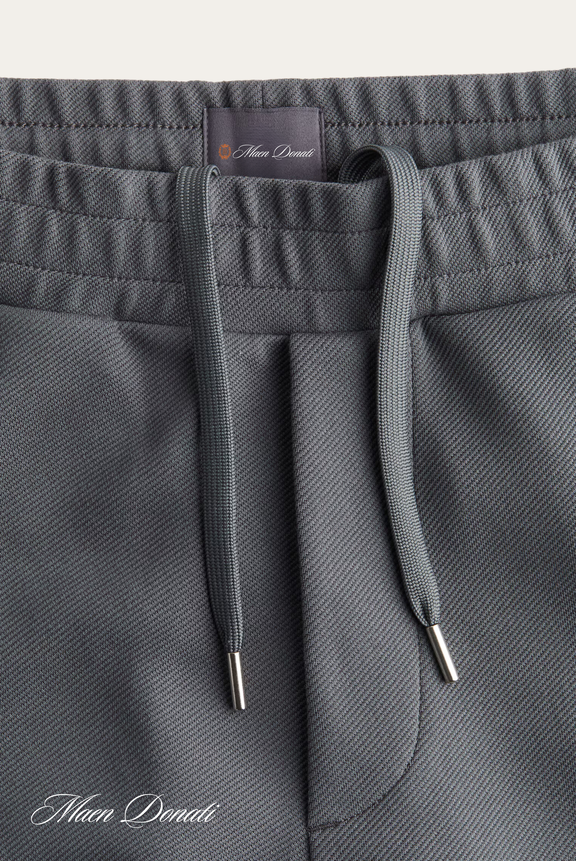Graue Jogginghose mit Kordelzug, Mikrofaser, bequem, sportlich, Herrenmode, Nahaufnahme.