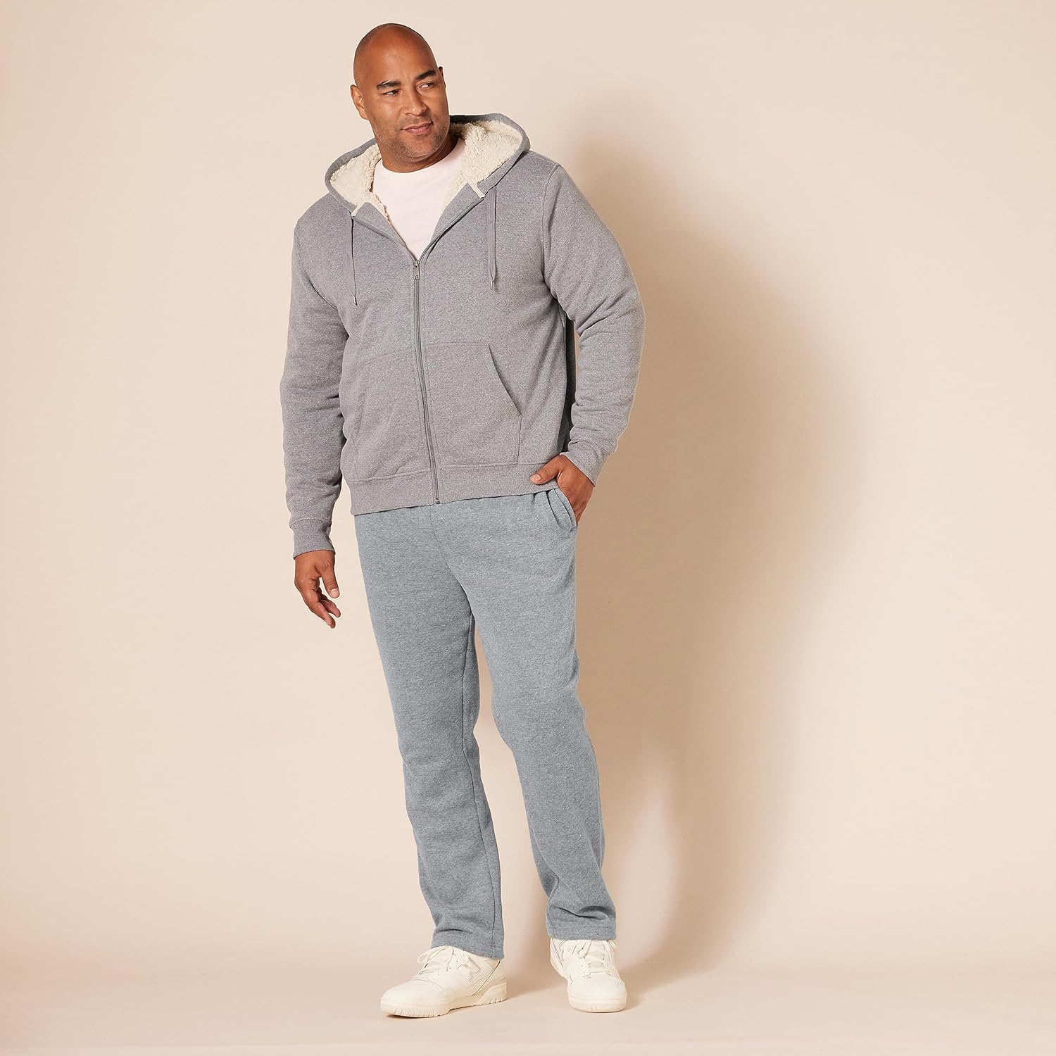 Mann in grauem Kapuzenpullover und Jogginghose, lässige Herrenmode, bequeme Freizeitkleidung.