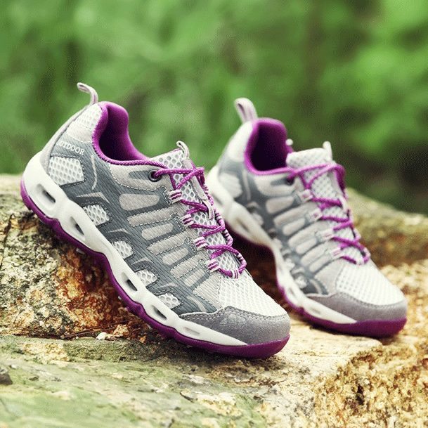 Graue und lila Wanderschuhe auf Felsen im Freien, atmungsaktiv und robust.