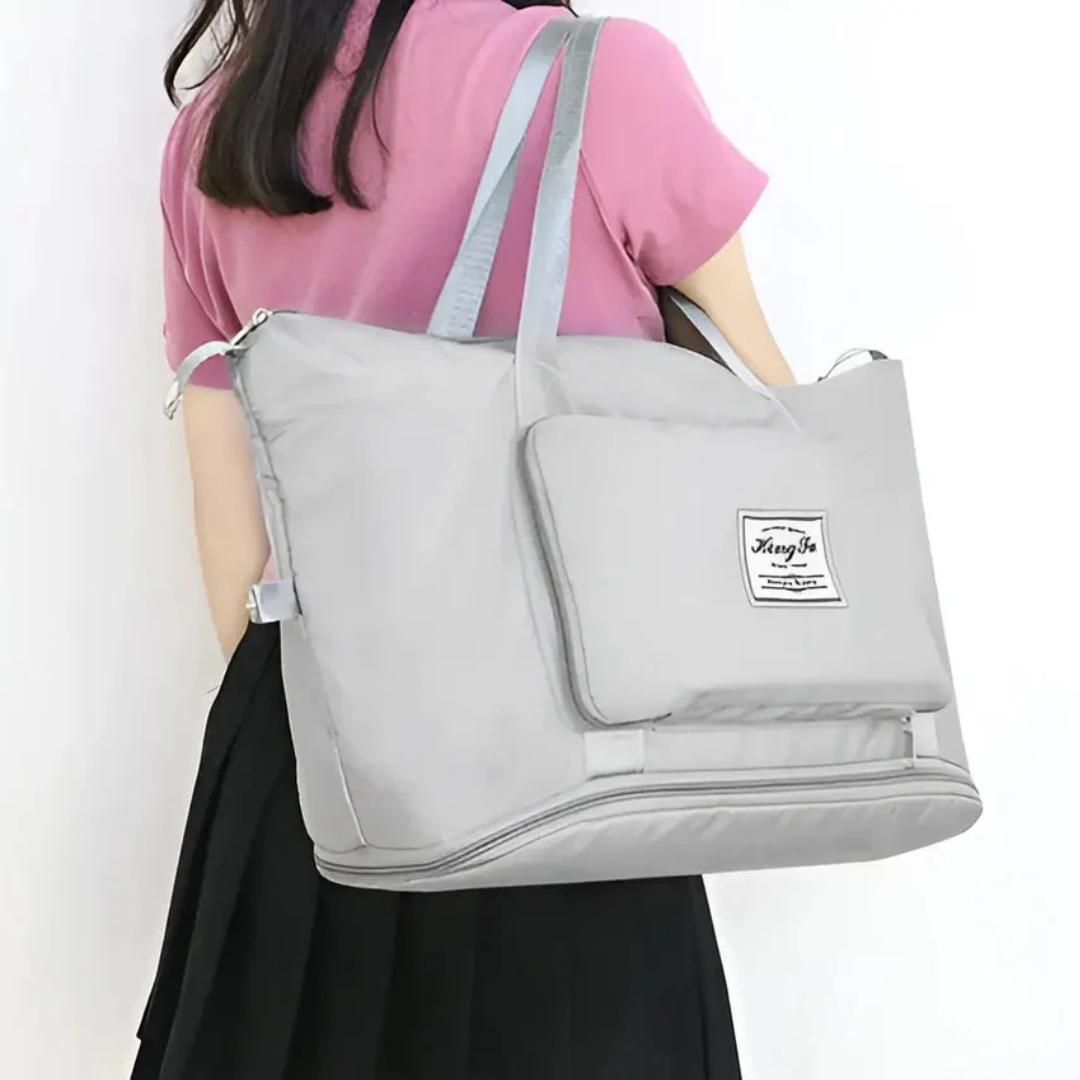 Frau mit großer grauer Reisetasche, Schultertasche, modisch, praktisch, Alltagsgebrauch.