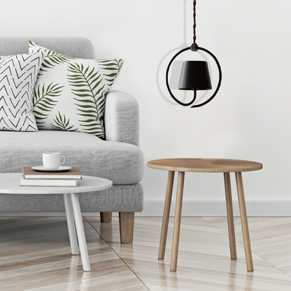 Graues Sofa mit Pflanzenkissen, runder Holztisch, moderne schwarze Hängelampe, skandinavisch.