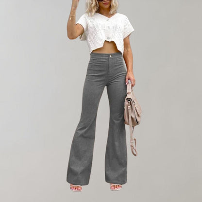 Frau in grauer Schlaghose und weißem Crop-Top, modisch, lässig, Sommeroutfit.
