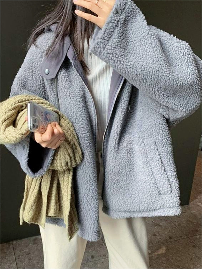Frau in grauer Teddyjacke mit Smartphone und Schal, Wintermode, gemütlich, warm, stilvoll.