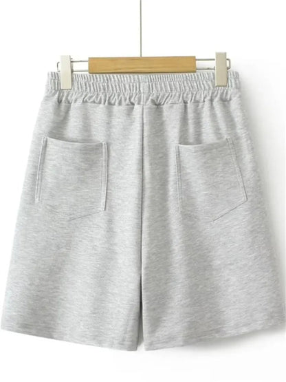 Graue Baumwollshorts mit elastischem Bund und Taschen, bequem für Freizeit und Sport.