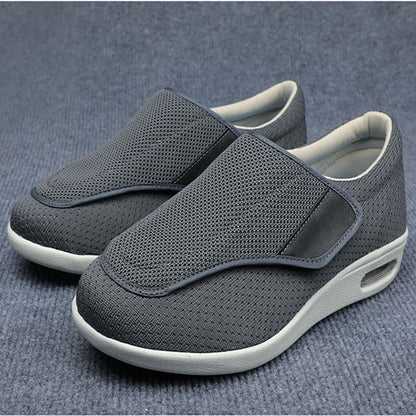 Graue orthopädische Schuhe für Herren, atmungsaktiv, bequem, rutschfest, auf Teppich.