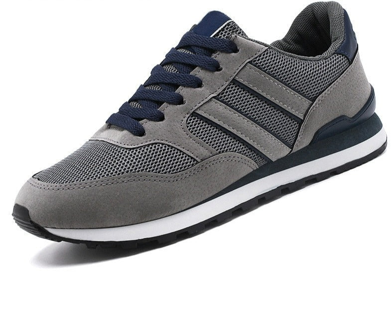 Grauer Sneaker mit blauen Akzenten, atmungsaktives Mesh, sportlicher Freizeitschuh für Herren.