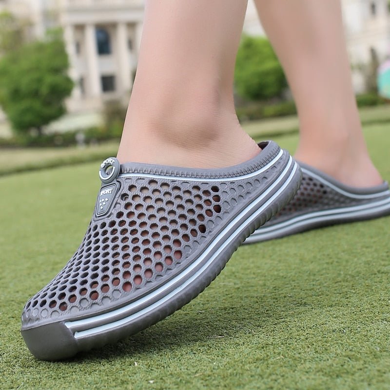 Graue atmungsaktive Sommerschuhe aus Mesh für Damen auf Rasen.