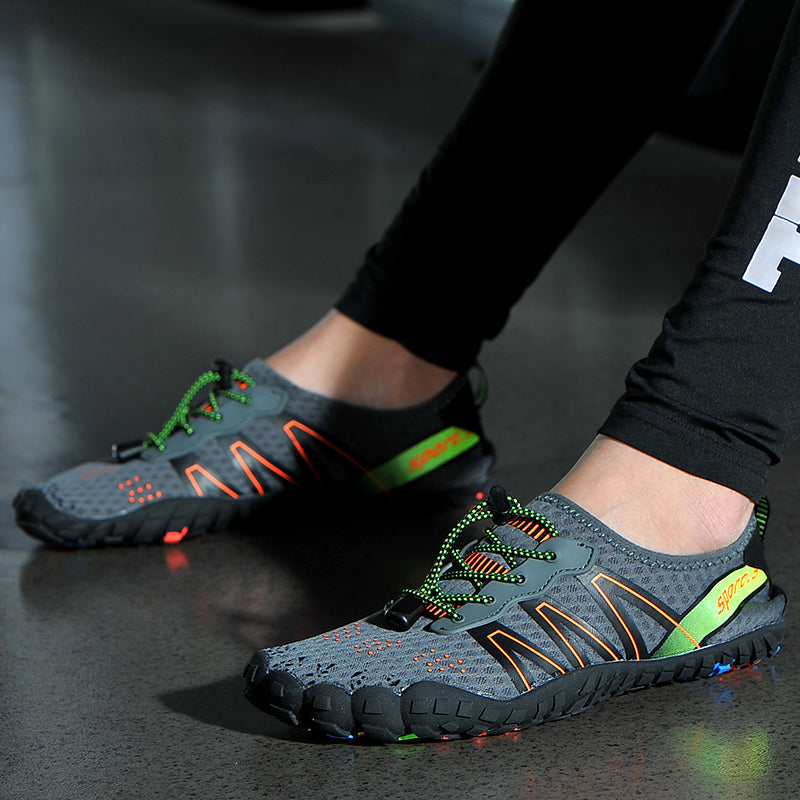 Graue Sportschuhe mit grünen Schnürsenkeln, rutschfeste Sohle, ideal für Outdoor-Aktivitäten.
